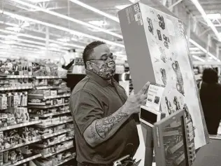  ?? Matthew Busch / Contributo­r ?? Milas Williams, founder of the nonprofit World Lolei, helps load an item purchased by a recipient of one of the $1,000 Christmas shopping sprees.