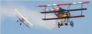  ??  ?? Here’s a typical scene from the WW I gaggle flight: Gerry Yarrish’s 1/3-scale Fokker Triplane trailing smoke as it is being pursued by Gene Gavin’s Nieuport 11.
