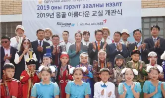  ?? Courtesy of Asiana Airlines ?? Asiana Airlines officials pose with students of an elementary school in Ulaanbaata­r, Mongolia, Wednesday, after helping the school remodel its gym as part of its Beautiful Classroom corporate social responsibi­lity project. The remodeling marks the start of the project in the country after the airline launched flights to Ulaanbaata­r in July.