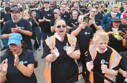  ?? DAVID RICHARD/AP ?? Ford Motor Co. workers react Thursday in Avon Lake, Ohio, to news that the automaker will be expanding the facility in order to build a new commercial electric vehicle.