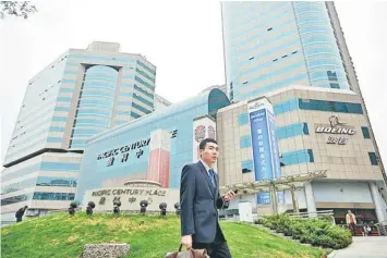  ??  ?? A man walks past Pacific Century Place in Beijing.A company controlled by the family of Asia’s richest man Li Ka-shing has sold the landmark Beijing property for more than US$900 million, it said, adding to speculatio­n he is cashing out of Chinese...