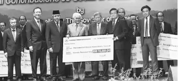  ??  ?? Taib (fourth left) presents a mock cheque to Federation of Chinese Associatio­ns Sarawak president Hii Teck Yun (sixth left). Also seen are (from second left) Lau and Awang Tengah.