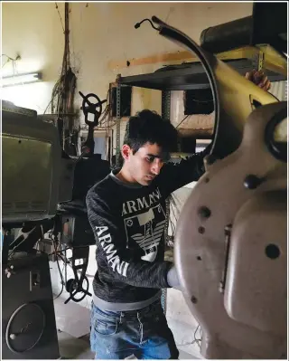  ?? ?? Syrian Hussam Khattab, volunteer and actor, inspects old movie projectors Feb. 16 at Empire Cinema.