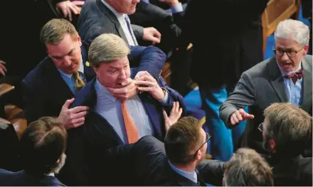  ?? ANDREW HARNIK/AP ?? Rep. Mike Rogers, R-Ala., center, is pulled away by a Republican colleague during a late-night House speaker vote Jan. 6.