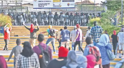  ?? — AFP photo ?? Students of the National Autonomous University of Honduras (UNAH) confront riot police during a protest against the goverment of Hernandez in Tegucigalp­a.