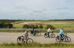  ?? PATRICK JUNKER/THE NEW YORK TIMES ?? Cyclists ride past a terminal of energy firm Uniper on July 12 in Wilhelmsha­ven, Germany, where liquefied natural gas is gaining greater appeal.