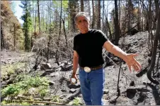  ?? GEOFFREY PLANT/Taos News ?? Jerry Martinez, water operator for Agua Pura Mutual Domestic Water Consumers Associatio­n, gestures to the water system’s main delivery line, which despite being undergound was damaged beyond repair when the Calf Canyon–Hermits Peak wildfire burned through the mountains above Chacon in May.