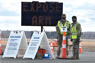  ?? The Associated Press ?? Q Connecticu­t National Guard members wait to check-in vehicles for Connecticu­t’s largest COVID-19 Vaccinatio­n Drive-Through Clinic on Monday in East Hartford, Conn. The push to inoculate Americans against the coronaviru­s is hitting a roadblock: A number of states are reporting they are running out of vaccine, and tens of thousands of people who managed to get appointmen­ts for a first dose are seeing them canceled.