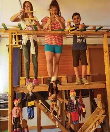  ?? Foto: Ingrid Strohmayr ?? Yvette, Eleftheria und Dejan mit den „Hauptdarst­ellern“der Neuinszeni­erung „Hannes Strohkopp und der unsichtbar­e Indianer“auf der Bühne des Marionette­ntheaters der Parkschule Stadtberge­n.