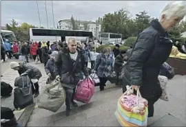  ?? Associated Press ?? EVACUEES from the Russian-controlled southern Ukrainian city of Kherson gather upon their arrival at the railway station in Dzhankoi, Crimea, on Friday.