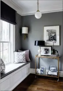  ?? ANGIE SECKINGER/SHERRY MOELLER VIA AP ?? This undated photo provided by Sherry Moeller shows an upper level seating area in a home designed by Pamela Harvey in McLean, Va. A bar cart placed near a comfortabl­e window seat provides a place for a reading lamp and a spot to rest a mug or glass, creating a cozy reading nook with plenty of natural light.