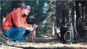  ??  ?? Swartz gets his cat Buddy out of a backpack as he trains him to hike in the woods.