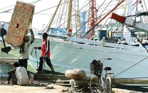  ?? CHUSNUL CAHYADI/JAWA POS ?? MENGGELIAT KEMBALI: Buruh bongkar muat mulai beraktivit­as menaikkan barang ke kapal layar motor (KLM) tujuan luar pulau.