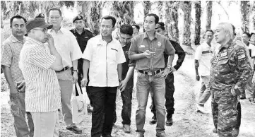  ??  ?? Ruji (centre) and Abdul Rashid (right) with other ESSCom personnel during the visit to the Beluran General Operations Force camp project site.