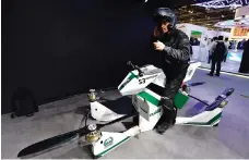  ?? Satish Kumar for The National ?? Top, the new Smart Tunnel at the Dubai Naturalisa­tion and Residency stand during the Gitex Technology Week at the World Trade Centre in Dubai. Above, an Emirati police officer checks a drone motorcycle