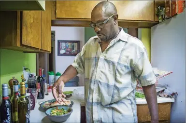  ?? HECTOR AMEZCUA/ SACRAMENTO BEE ?? Simeon Gant of Sacramento, Calif., prepares a salad for his dinner on July 6. Gant gave up pork 20 years ago, then beef five years ago. He no longer cooks chicken at home but occasional­ly eats it when he’s out. He’s one of a growing number of people...