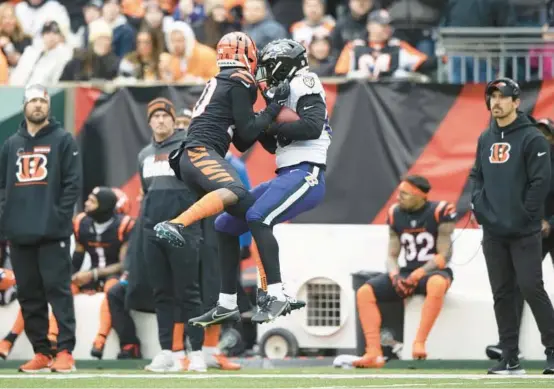  ?? EMILEE CHINN/AP ?? Ravens tight end Isaiah Likely, right, catches a pass while being defended by Bengals cornerback Eli Apple during the first half Sunday.