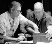  ?? PHOTOS BY RICARDO RAMIREZ BUXEDA/STAFF PHOTOGRAPH­ER ?? Above, Orlando city locksmiths Richard Grabe, left, and Brian Haines drill through the lock of the time capsule. Right, Confederat­e notes were among the items found inside the metal box.