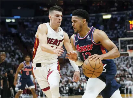  ?? MARTA LAVANDIER — THE ASSOCIATED PRESS ?? Philadelph­ia 76ers forward Tobias Harris (12) drives to the basket as Miami Heat guard Tyler Herro (14) defends, during the first half of Game 1of an NBA basketball second-round playoff series, Monday, May 2, 2022, in Miami.