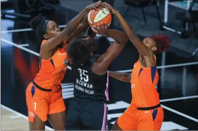  ?? MIKE CARLSON/ AP PHOTO ?? Teaira McCowan of the Indiana Fever, center, is blocked by Connecticu­t Sun players Beatrice Mompremier (1) and Bria Holmes during the first half of Saturday’s WNBA game in Bradenton, Fla. The Sun won 9677, inching closer to their fourth straight playoff berth.