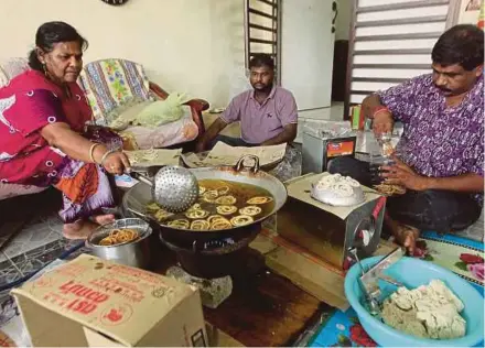  ?? PIC BY MUHAMMAD ASYRAF SAWAL ?? A. Jayachanth­iran (right) and his wife, M. Thivanney, preparing muruku ordered by customers for Deepavali at their home in Taman Shahzan, Kuantan, recently.