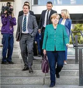  ??  ?? In Bedrängnis: Kanzlerin Angela Merkel, ihr Regierungs­sprecher Steffen Seibert (links) und Beraterin Eva Christians­en verlassen nach der CDU-Sondersitz­ung den Bundestag.