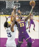  ?? Mark J. Terrill ?? The Associated Press Lakers forward Lebron James goes up for a shot against Timberwolv­es guard Jimmy Butler during the first half of Los Angeles’ 114-110 home win.