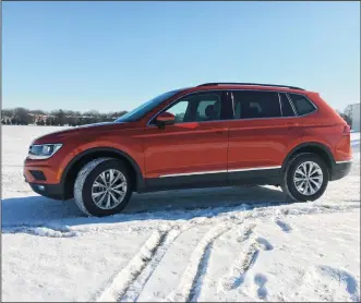  ?? ROBERT DUFFER/ CHICAGO TRIBUNE ?? The 2018 Volkswagen Tiguan SE with AWD in Habanero Orange paint coat is powered by a revised 2-liter turbocharg­ed 4-cylinder engine with variable valve timing. It’s longer and heavier than the outgoing model, yet more fuel efficient and powerful. The...