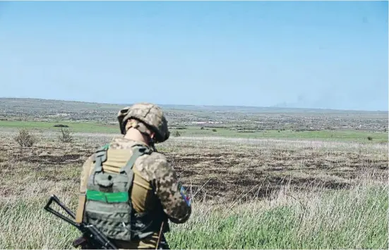  ?? SERHII NUZHNENKO / REUTERS ?? Un soldat ucraïnès contempla les prades del Donbass sotmeses al foc de l’artilleria russa