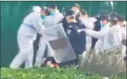  ?? AP ?? Security personnel in protective clothing surround and kick a protester after he grabbed a metal pole that had been used to strike him at the Apple iphone factory in Zhengzhou.