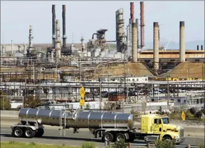  ??  ?? This March 9, 2010, file photo shows a tanker truck passing the Chevron oil refinery in Richmond. A U.S. judge who held a hearing about climate change that received widespread attention has thrown out the underlying lawsuits that sought to hold big oil companies liable for the role of fossil fuels in the Earth’s warming environmen­t. AP PHOTO/PAUL SAKUMA