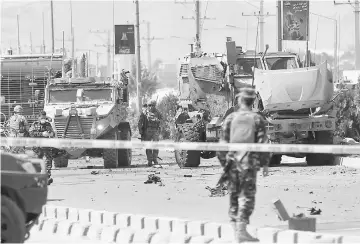  ??  ?? Nato troops investigat­e a Danish convoy at the site of a car bomb attack in Kabul. — Reuters photo