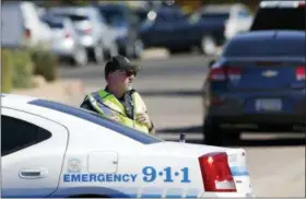  ?? ROSS D. FRANKLIN — THE ASSOCIATED PRESS ?? A Scottsdale Police Department officer blocks off traffic as police surround a local hotel where a suspect wanted in several killings was staying Monday in Scottsdale, Ariz. According to police, the suspect killed himself as police closed in on the...