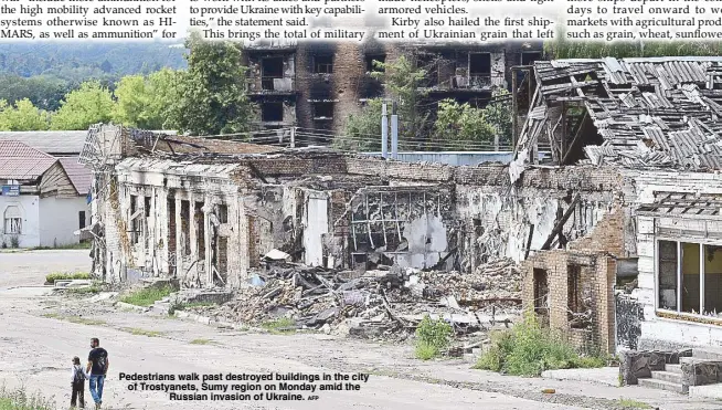  ?? AFP ?? Pedestrian­s walk past destroyed buildings in the city of Trostyanet­s, Sumy region on Monday amid the Russian invasion of Ukraine.