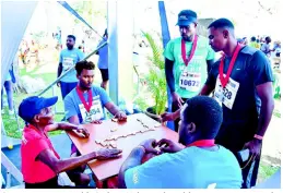  ??  ?? Seventy-nine-year-old Gerline Nelson, the oldest participan­t in the MoBay City Run, playing dominoes at the Courts Chill Zone.