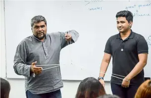  ??  ?? Skills Academy chief operating officer Kumar Nagalingam (left) challenges students with a puzzle during Orientatio­n week.