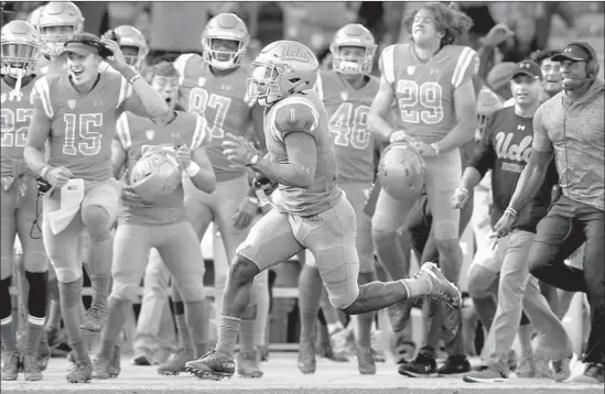  ?? Luis Sinco Los Angeles Times ?? DARNAY HOLMES, who felt he had to make amends after surrenderi­ng a touchdown on defense, returns a Stanford kickoff 93 yards for a score in the third quarter.