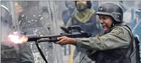  ??  ?? CRACKDOWN: A soldier fires his shotgun at protesters in the capital Caracas