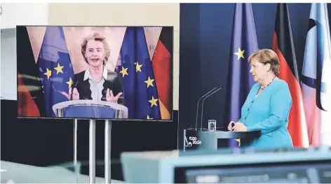  ?? FOTO: DPA ?? Weit entfernt, trotzdem nah beieinande­r: Ursula von der Leyen (l.) und Angela Merkel am Donnerstag.