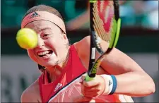  ?? CHRISTOPHE ENA/AP PHOTO ?? Latvia’s Jelena Ostapenko returns the ball to Ukraine’s Kateryna Kozlova during their first round match at the French Open on Sunday at Roland Garros Stadium in Paris.