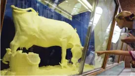  ?? TED SCHURTER/THE STATE JOURNAL-REGISTER FILE ?? A fairgoer points to the butter cow at the Illinois State Fair in Springfiel­d in 2004.