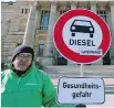  ??  ?? A protester stands in front of the Federal Administra­tive Court in Leipzig, Germany, before Tuesday’s verdict. The sign below the diesel icon translates to “Health risk.”