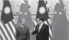  ??  ?? Malaysia’s Prime Minister Mahathir Mohamad (L) and China’s Premier Li Keqiang chat during a signing ceremony at the Great Hall of the People in Beijing, China, August, 20, 2018 (REUTERS)