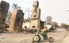  ?? REED SAXON/AP ?? A child's toy stands outside a home destroyed by the Woolsey Fire in Malibu, as blazes ravaged Northern and Southern California.