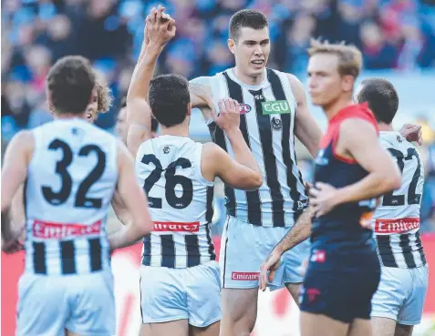  ??  ?? STAR OF THE SHOW: Giant Magpie Mason Cox (third from left) reacts after kicking a goal yesterday. Picture: AAP