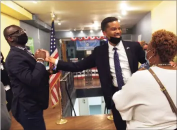  ?? Christian Abraham / Hearst Connecticu­t Media ?? Corey Paris, Democratic candidate for the state House's 145th District seat, celebrates with supporters Jamarr Brown, left, and Bianca Shinn after winning the special election on Tuesday.