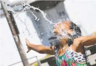  ?? DON MACKINNON / AFP VIA GETTY IMAGES ?? Kids cool off last week on a scorching day in Richmond,
B.C. Several areas in B.C. broke temperatur­e records.