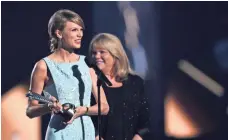  ?? COOPER NEILL/GETTY IMAGES ?? Taylor Swift accepts the Milestone Award from her mother at the 2015 Academy of Country Music Awards. Her mom’s cancer battle gave Swift a new perspectiv­e.