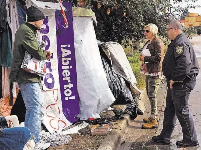  ?? Jerry Baker ?? Harris County Sheriff ’s Office Deputy and Homeless Outreach Team member Luke Ditta, right, and Hope Haven President and Executive Director Kristyn Stillwell visit with a homeless man in the FM 1960 area earlier this month.