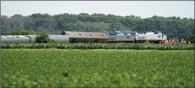  ?? (AP/Charlie Riedel) ?? Workers gather at the front of a derailed Amtrak train on Tuesday near Mendon, Mo.